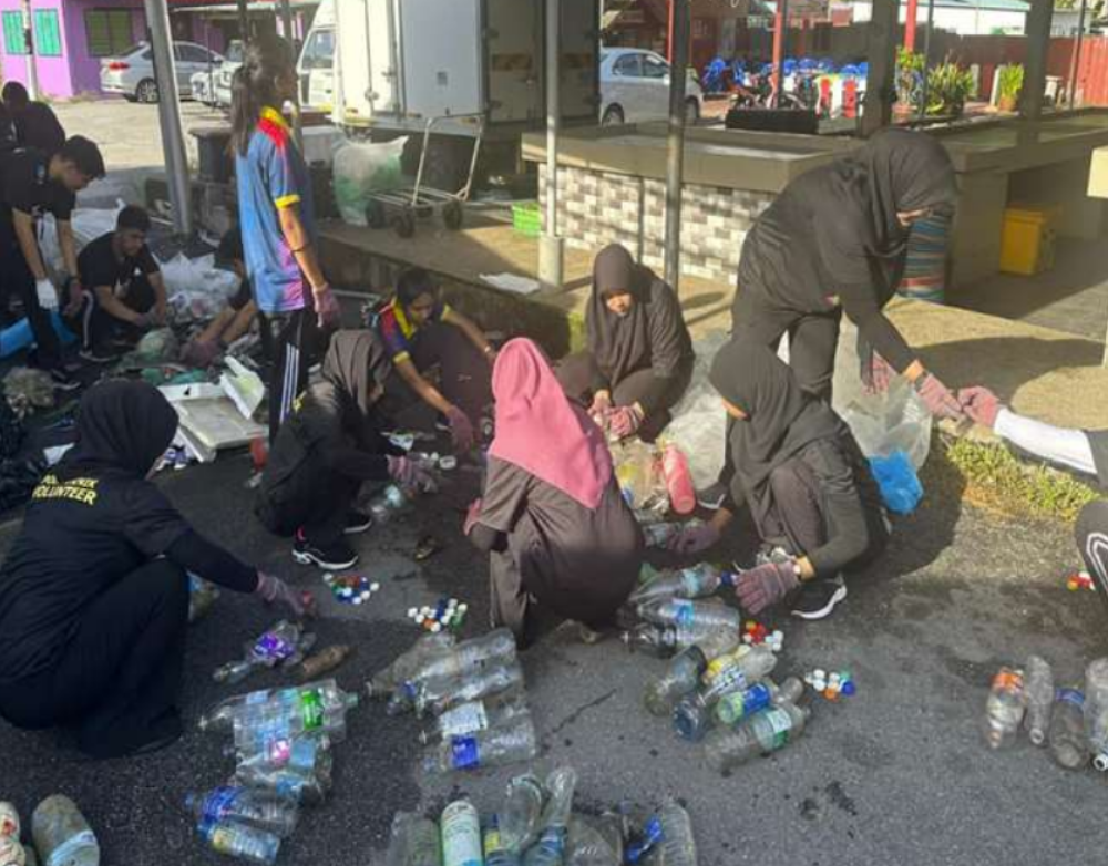 Peserta mengasingkan botol plastik dan sisa yang dikumpulkan untuk pengurusan yang lebih teratur.